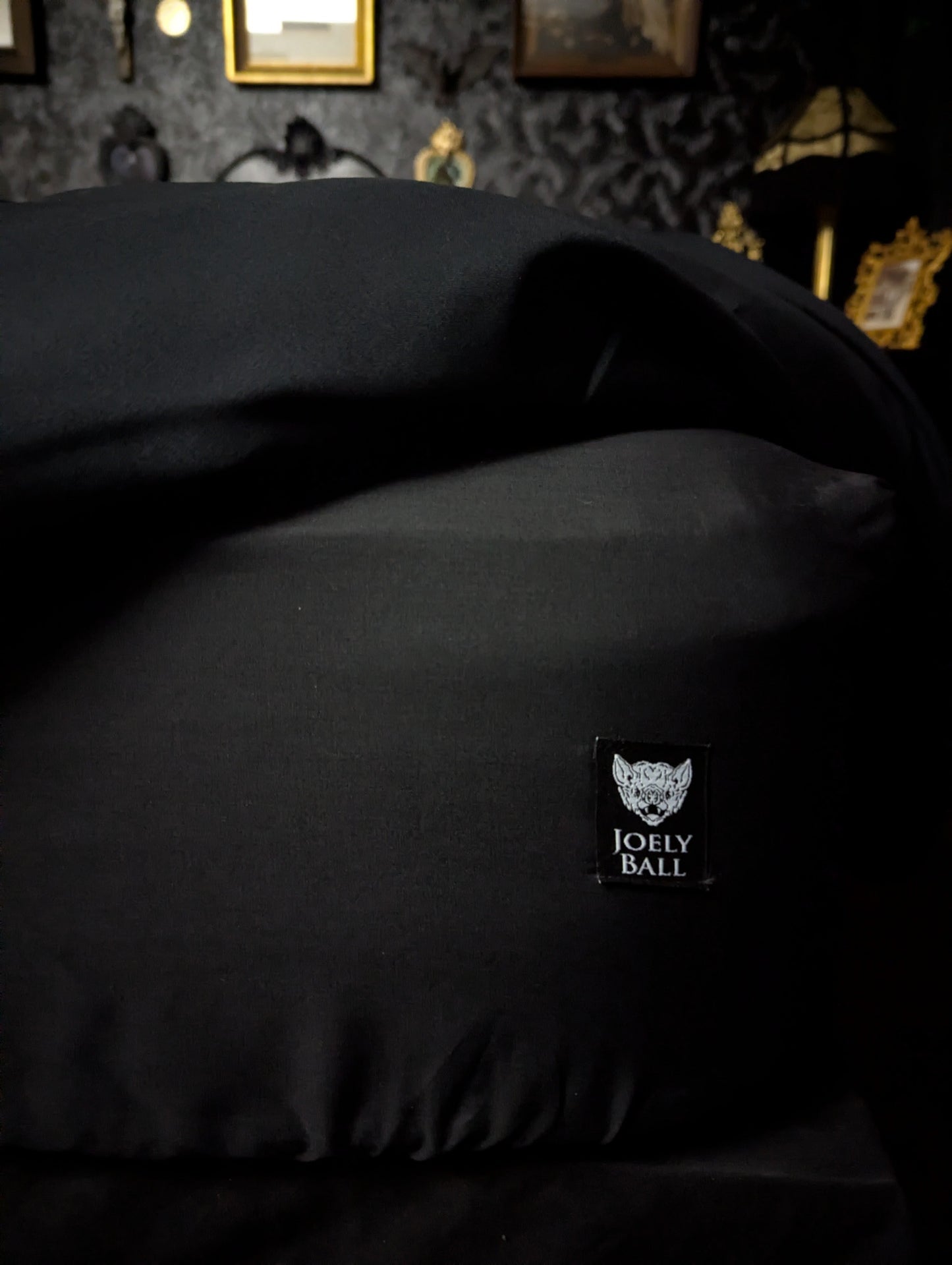 Black bed sheet with a brand label in a darkly decorated room