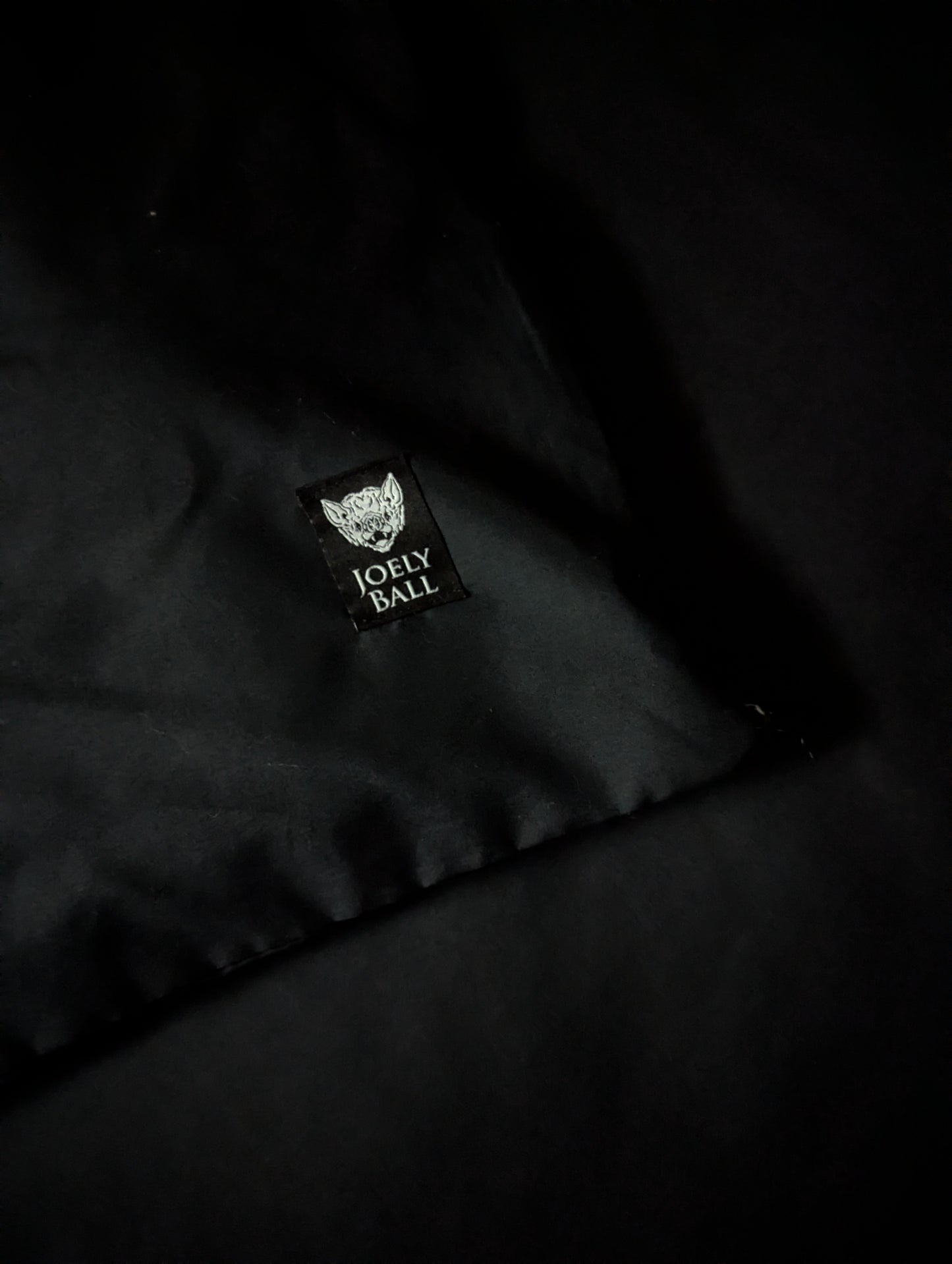 Black duvet with a 'Joely Ball' logo on a dark background