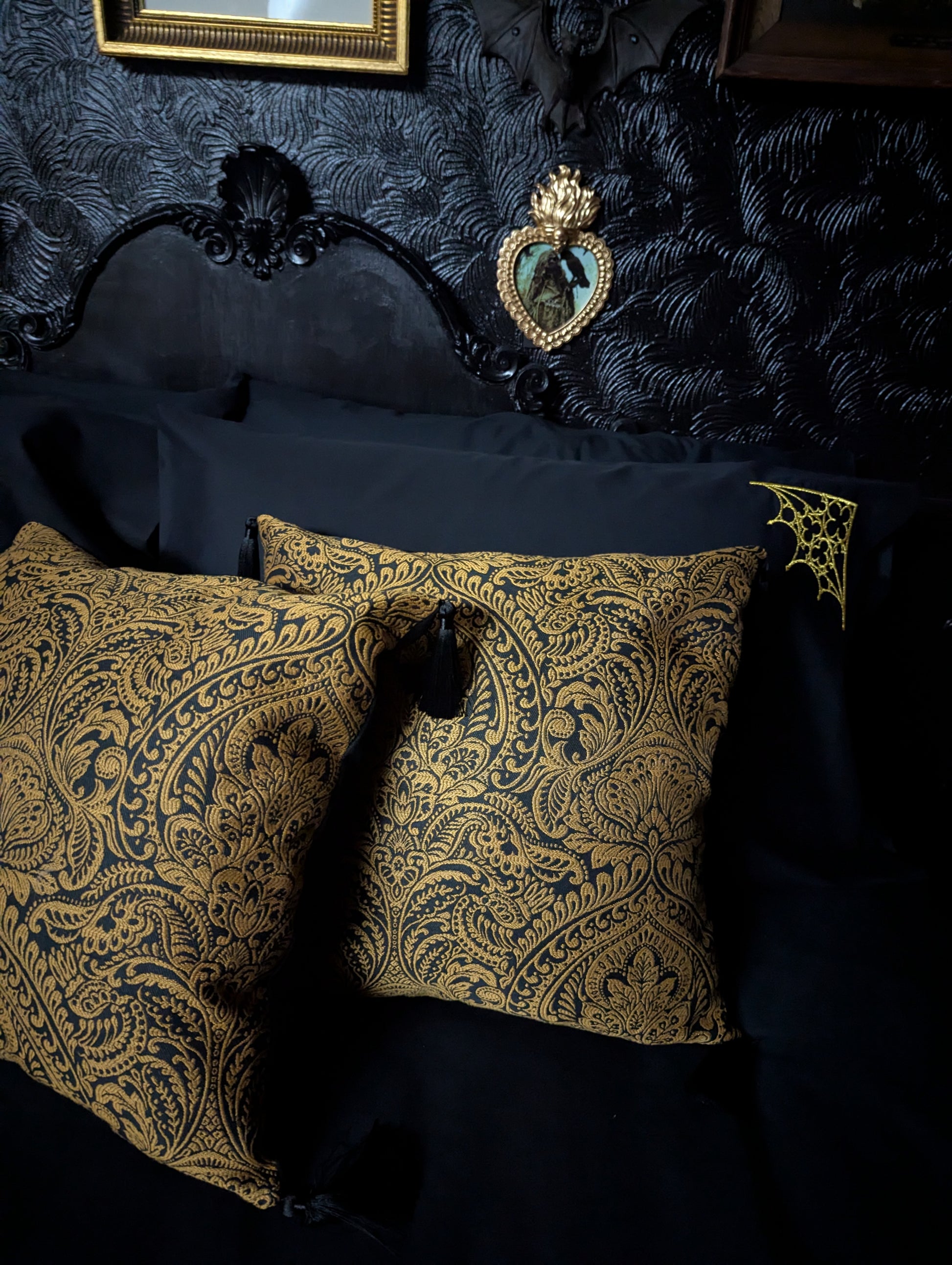 Decorative pillows with gold damask pattern on a dark background