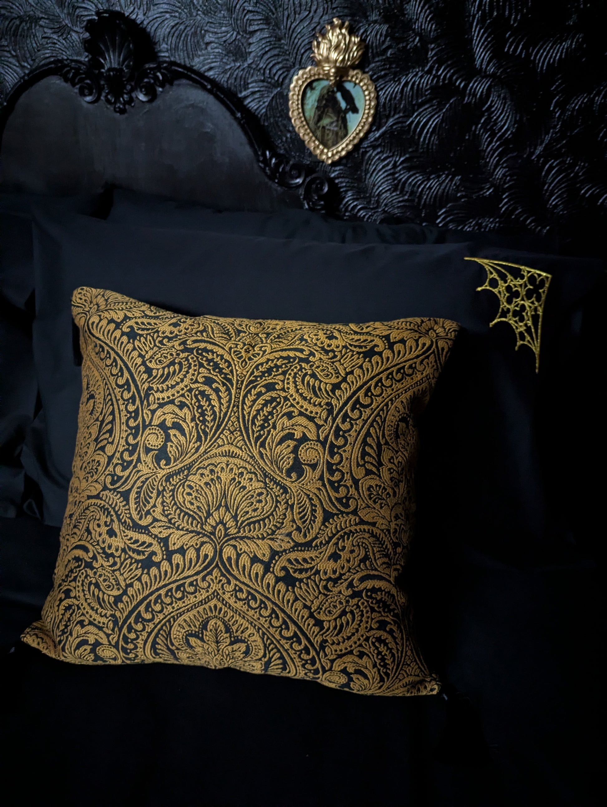 Decorative gold pillow with a damask pattern on a dark background