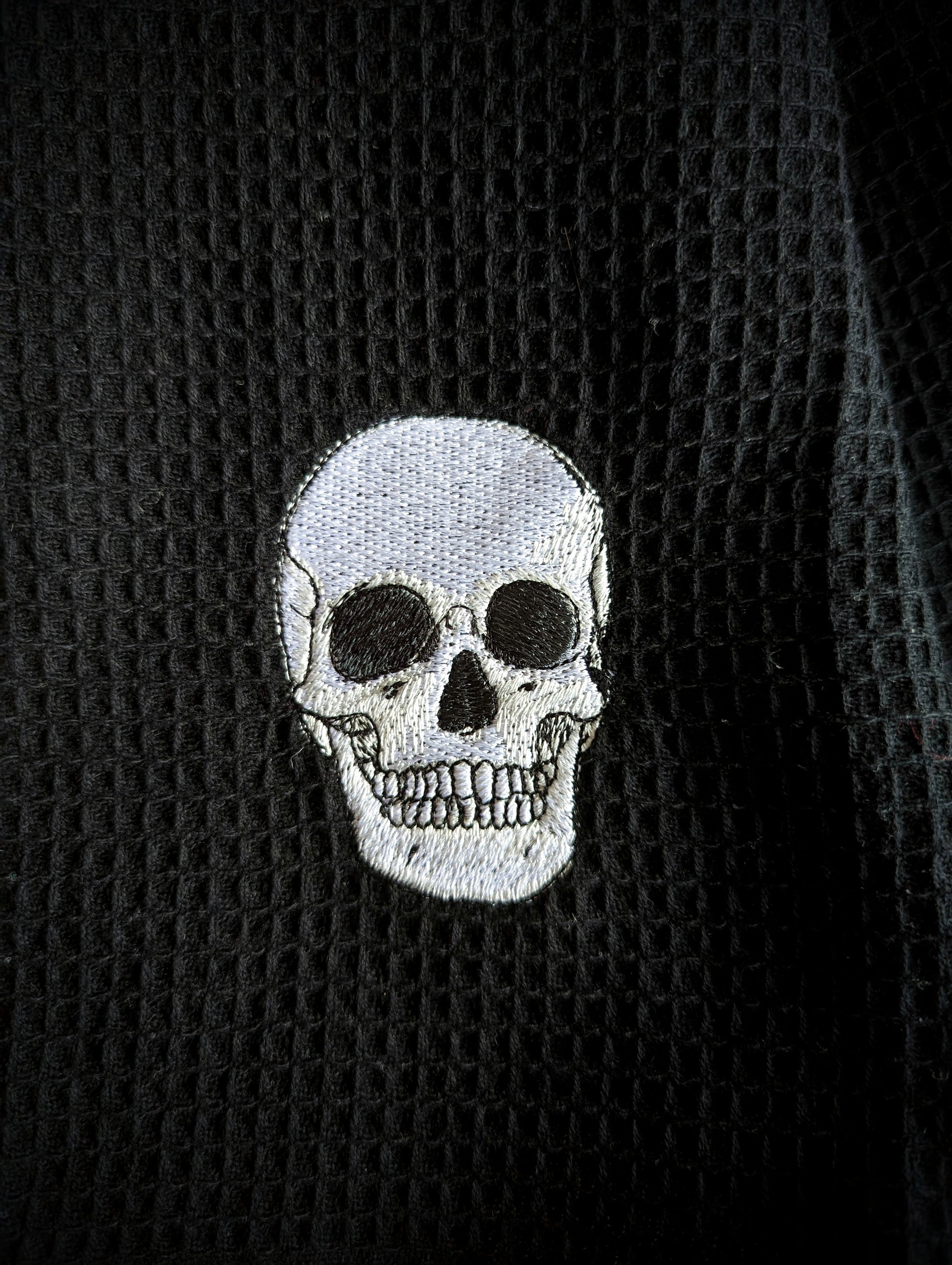 Embroidered anatomical skull on cotton waffle fabric.