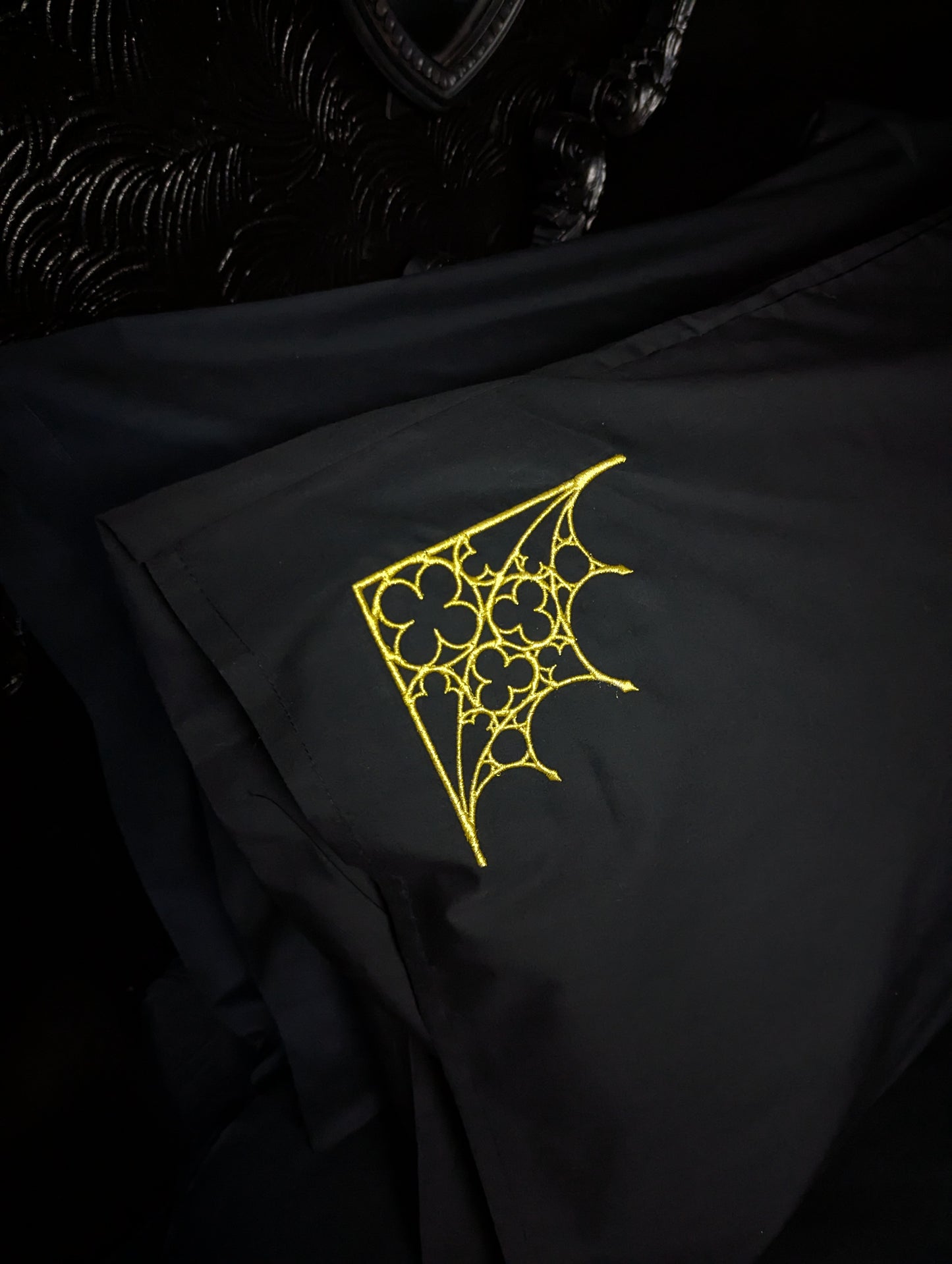 Black pillowcase with gold tracery design on a dark background