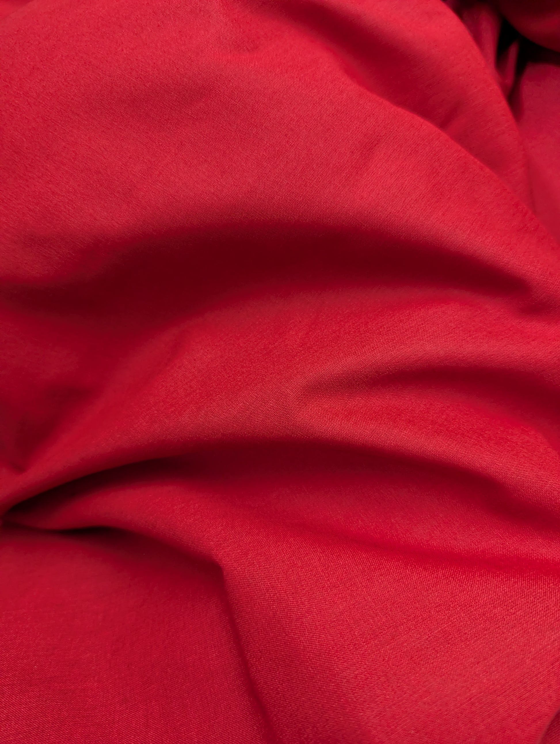 Close-up of red bedding fabric with folds