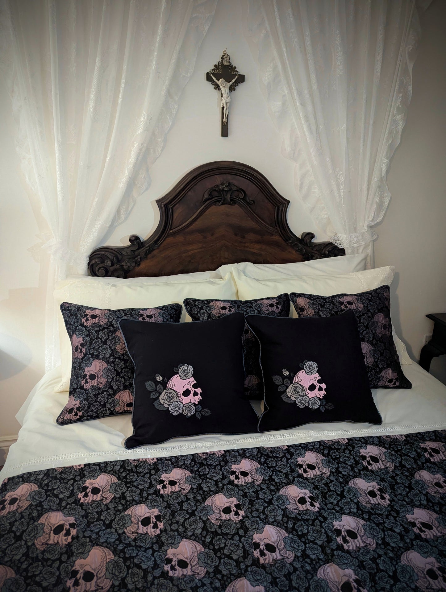 Bed with skull-patterned bedding and pillows in a bedroom setting.