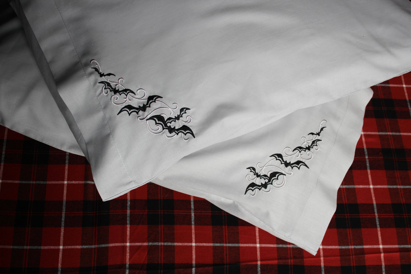 Silver grey pillowcases embroidered with bats and scrolls in black